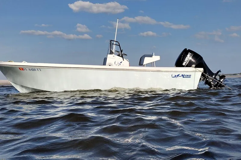 The Image of 1986 Mako 17 Center Console boat on water, Suzuki outboard motor, clear sky. - 1