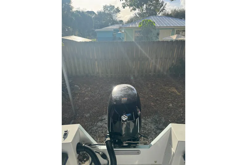 Slide: The Image of 1986 Mako 17 Center Console boat with Suzuki outboard motor in a backyard setting. - 10