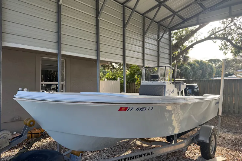 Slide: The Image of 1986 Mako 17 Center Console boat on trailer under metal shelter. - 2