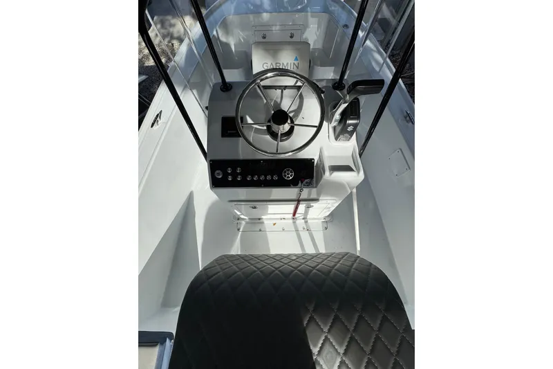Slide: The Image of 1986 Mako 17 Center Console boat interior with steering wheel and Garmin navigation. - 6