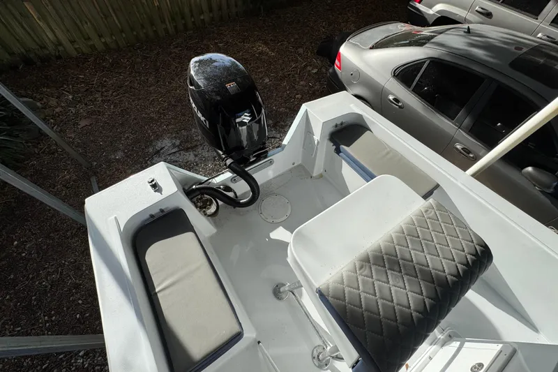 Slide: The Image of 1986 Mako 17 Center Console boat with Suzuki outboard motor, parked near cars. - 8
