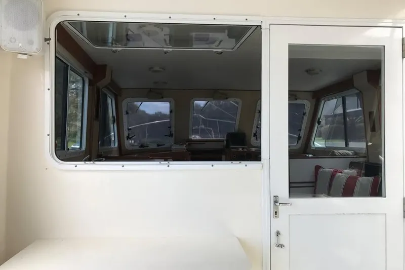 Slide: The Image of Cabin interior of a 2001 Wesmac 38 boat, featuring windows and seating. - 10