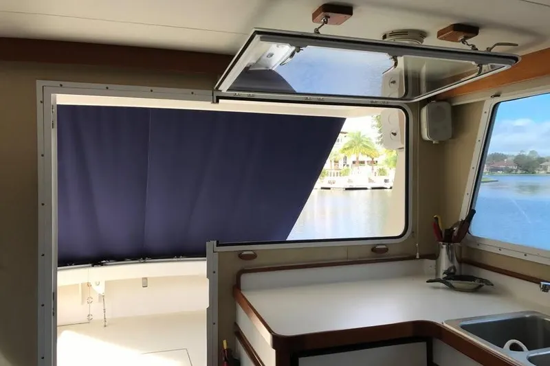 Slide: The Image of Interior view of 2001 Wesmac 38 boat with open window and waterfront scenery. - 11