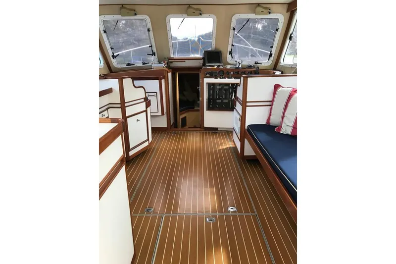 Slide: The Image of Interior of 2001 Wesmac 38 boat with wood flooring and cushioned seating. - 13