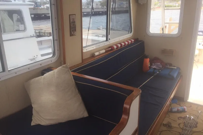 Slide: The Image of Interior of 2001 Wesmac 38 boat with blue cushioned seating and large windows. - 15