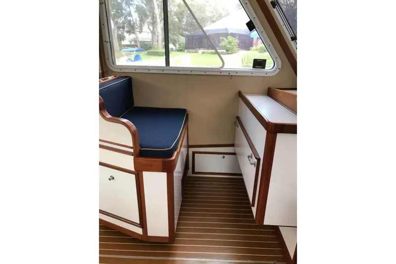 Slide: The Image of Interior of 2001 Wesmac 38 boat with wooden trim and blue cushioned seating. - 16