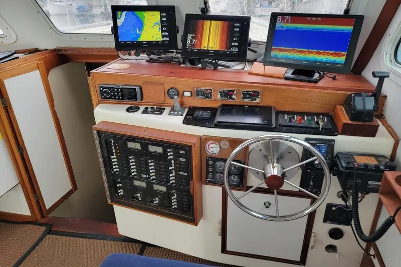 Slide: The Image of 2001 Wesmac 38 boat cockpit with navigation screens, steering wheel, and control panels. - 19