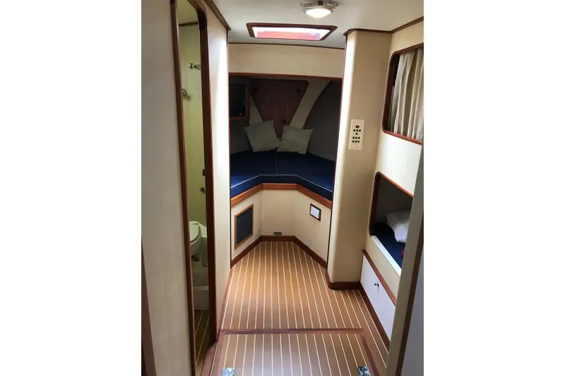 Slide: The Image of Interior of 2001 Wesmac 38 boat, featuring cozy cabin with wood flooring and seating. - 20