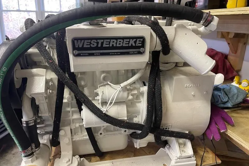 Slide: The Image of Westerbeke engine in a 2001 Wesmac 38 boat, surrounded by hoses and tools. - 23