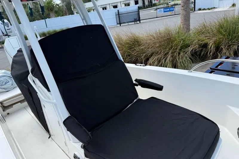 Slide: The Image of 2024 Boston Whaler 250 Dauntless boat on trailer, parked outdoors under cloudy sky. - 16