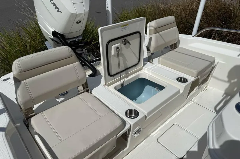 Slide: The Image of 2024 Boston Whaler 250 Dauntless boat with canopy, parked under a partly cloudy sky. - 4