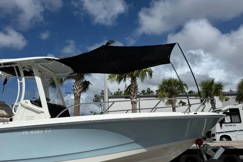 Slide: The Image of 2024 Boston Whaler 250 Dauntless boat interior with cushioned seating and wooden table. - 5