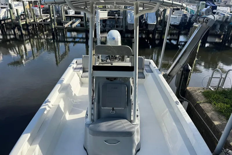 Slide: The Image of 2022 Avid 23 FS Magnum boat docked at marina, showcasing spacious deck and seating. - 10