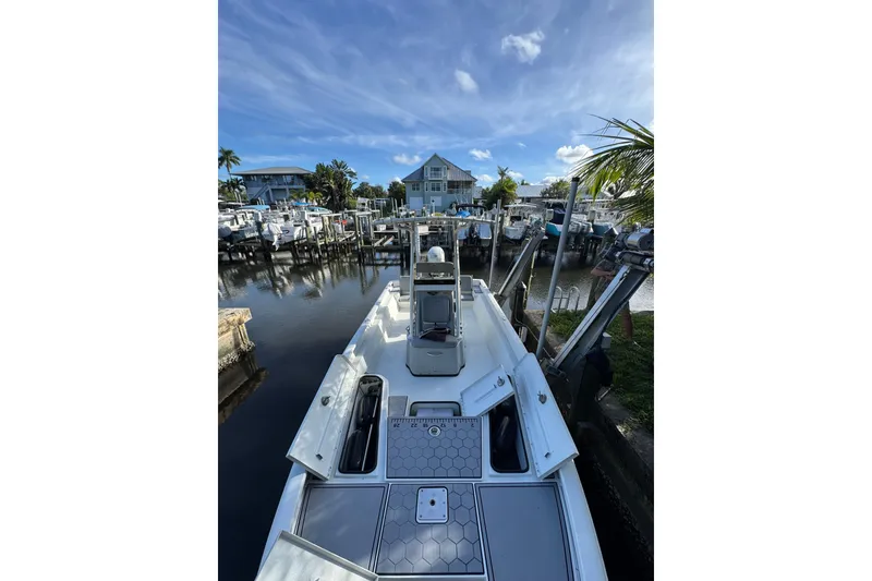 Slide: The Image of 2022 Avid 23 FS Magnum boat docked in a marina under a clear blue sky. - 11