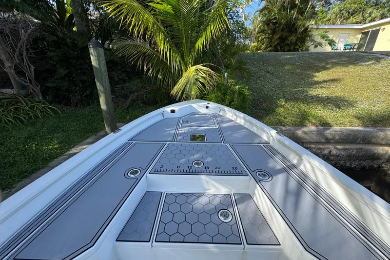 Slide: The Image of 2022 Avid 23 FS Magnum boat deck with hexagonal pattern and lush greenery backdrop. - 12