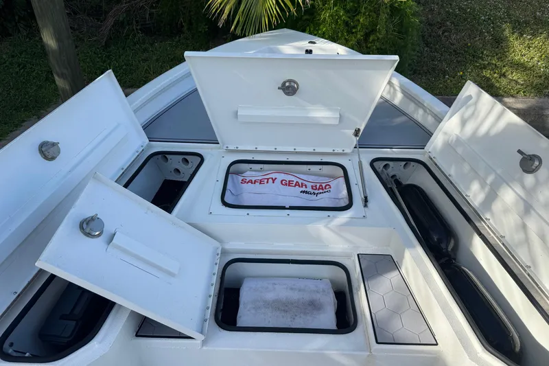 Slide: The Image of Open storage compartments on a 2022 Avid 23 FS Magnum boat deck. - 13