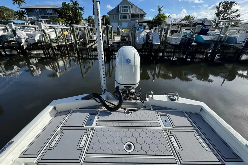Slide: The Image of 2022 Avid 23 FS Magnum boat docked, featuring a Suzuki outboard motor and spacious deck. - 15