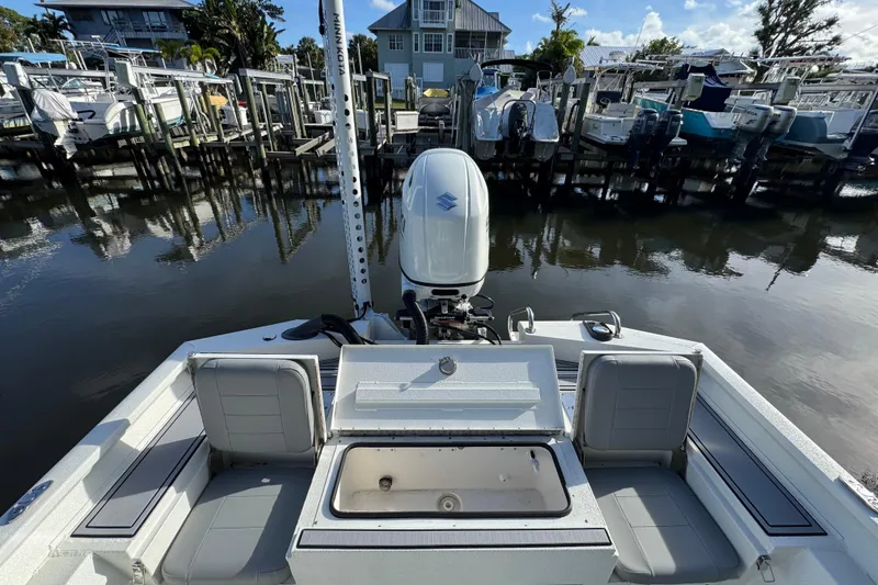 Slide: The Image of 2022 Avid 23 FS Magnum boat docked, featuring a Suzuki outboard motor and spacious seating. - 16