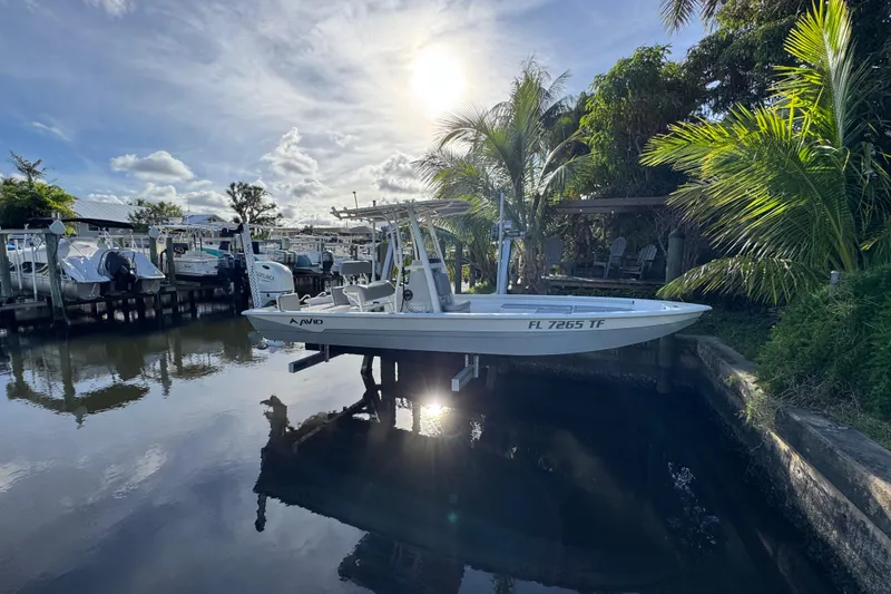Slide: The Image of 2022 Avid 23 FS Magnum boat docked by palm trees under a bright sun. - 4