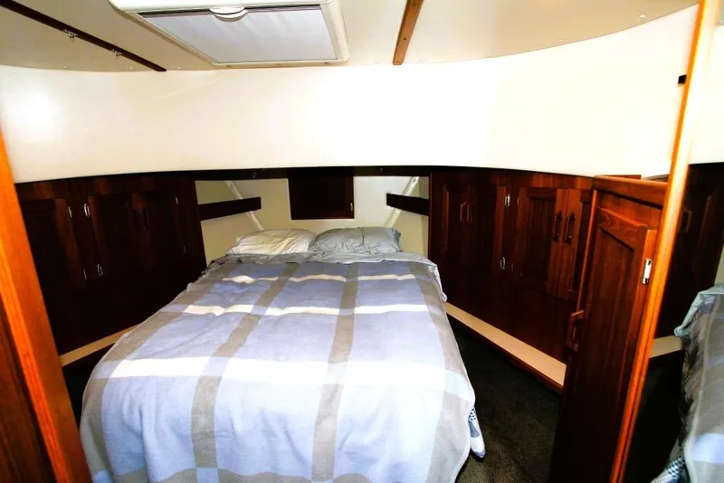 Slide: The Image of Cozy bedroom in 2002 Nordic Tug 37 with wood cabinetry and striped bedding. - 10