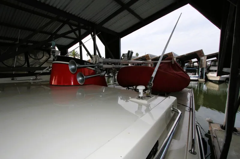 Slide: The Image of 2002 Nordic Tug 37 docked under a covered marina, showcasing deck details. - 13