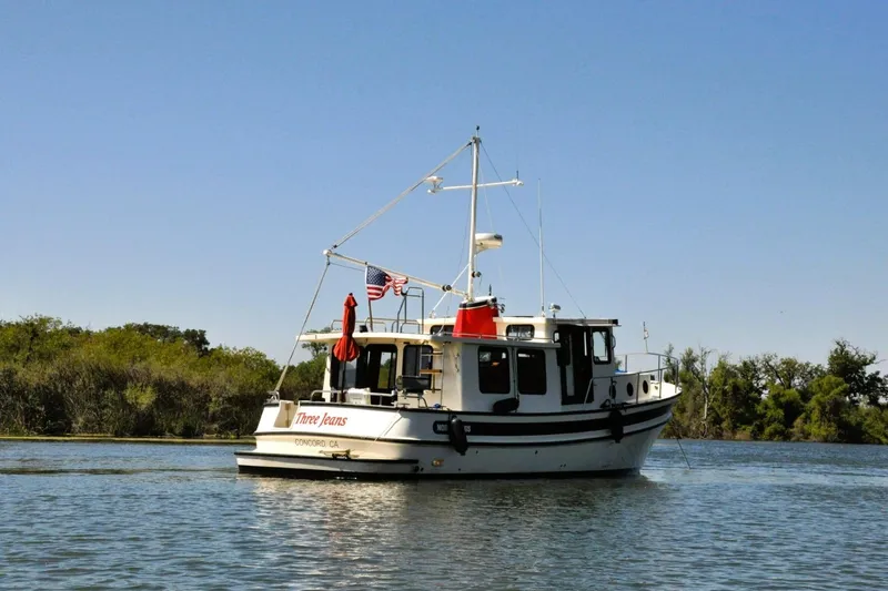 Slide: The Image of 2002 Nordic Tug 37 boat on calm water with clear blue sky. - 3