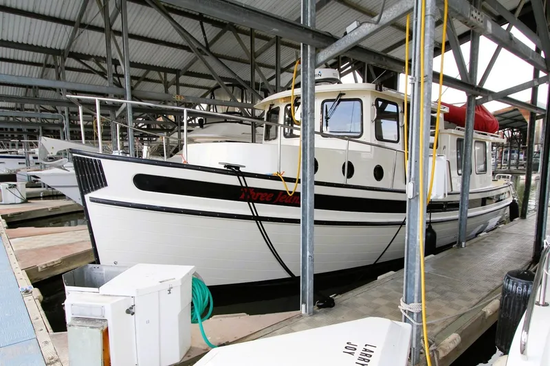 Slide: The Image of 2002 Nordic Tug 37 docked in a covered marina, side view. - 4