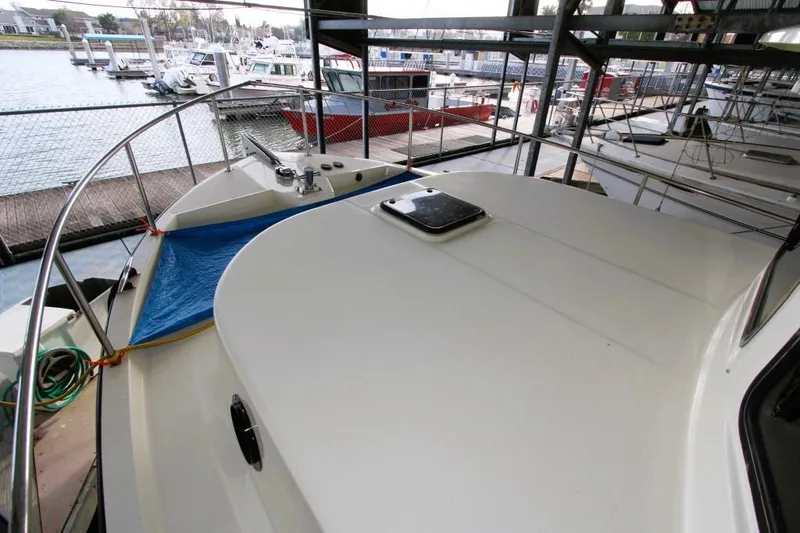 Slide: The Image of 2002 Nordic Tug 37 docked in marina, showcasing deck and railing. - 6