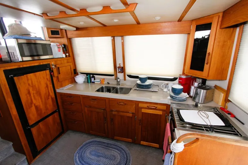 Slide: The Image of Cozy kitchen in 2002 Nordic Tug 37 with wooden cabinets and modern appliances. - 7