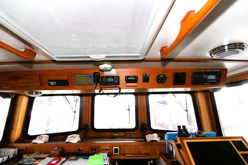 Slide: The Image of 2002 Nordic Tug 37 interior helm with navigation equipment and wooden finish. - 9