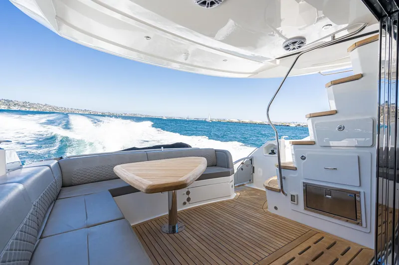 Slide: The Image of 2018 Sea Ray L590 Fly yacht interior with ocean view and wooden deck. - 10