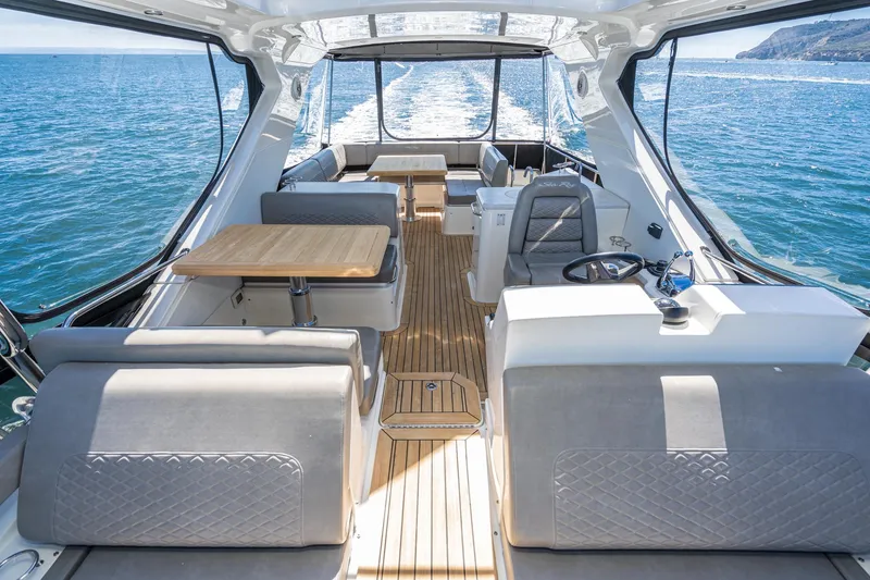 Slide: The Image of 2018 Sea Ray L590 Fly yacht interior with ocean view, featuring luxurious seating and dining area. - 11