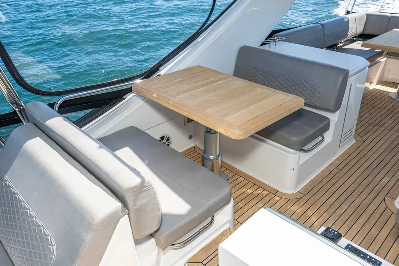 Slide: The Image of 2018 Sea Ray L590 Fly yacht interior with seating and wooden table. - 16