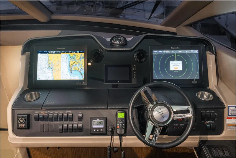 Slide: The Image of 2018 Sea Ray L590 Fly helm with dual navigation screens and steering wheel. - 48
