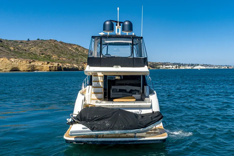 Slide: The Image of 2018 Sea Ray L590 Fly yacht on the water with scenic coastal background. - 7