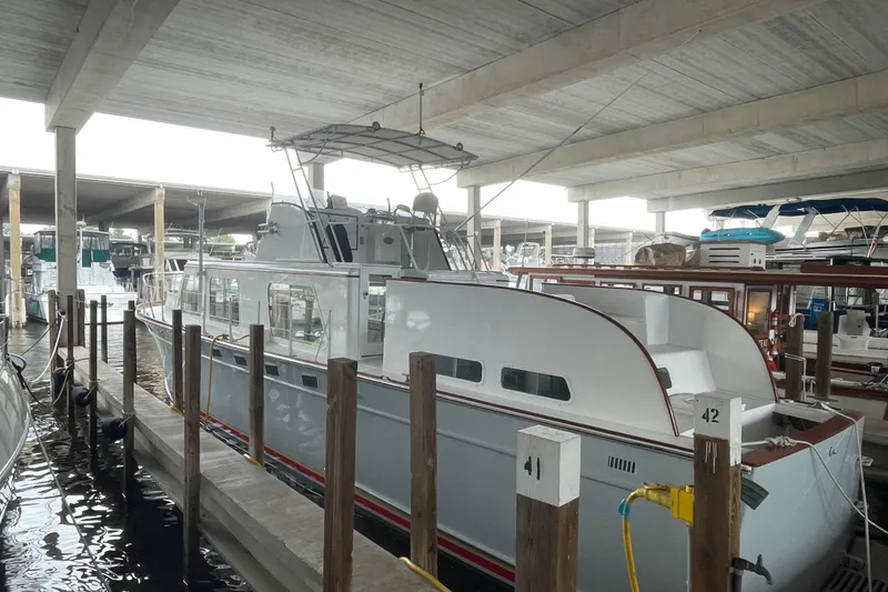 The Image of 1958 Huckins Seafarer yacht docked in a covered marina, showcasing classic design. - 1