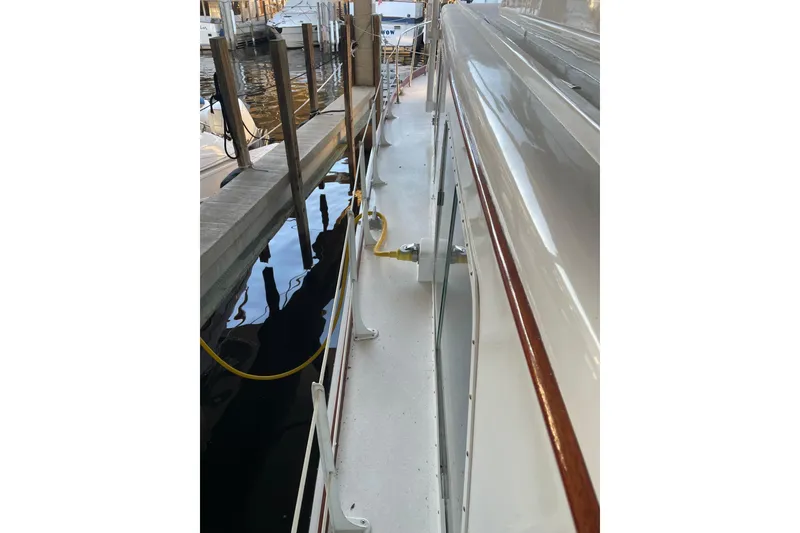 Slide: The Image of 1958 Huckins Seafarer yacht docked, showcasing sleek deck and classic design. - 11