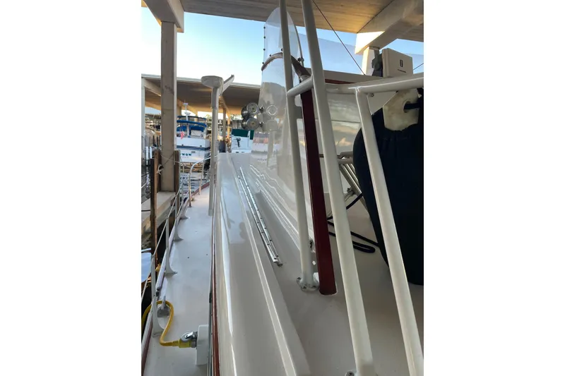 Slide: The Image of 1958 Huckins Seafarer boat docked, showcasing sleek deck and railing design. - 12