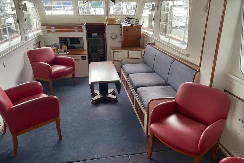 Slide: The Image of Interior of a 1958 Huckins Seafarer yacht with red chairs and a blue sofa. - 16