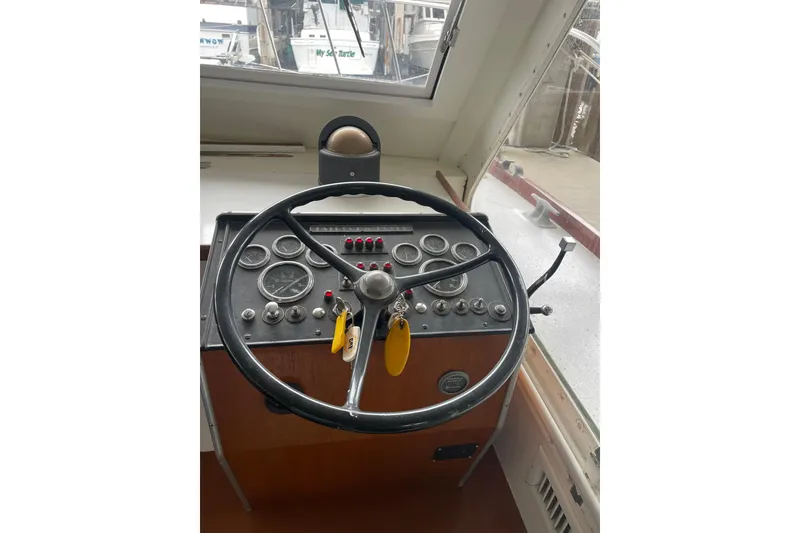 Slide: The Image of 1958 Huckins Seafarer helm with vintage steering wheel and instrument panel. - 17