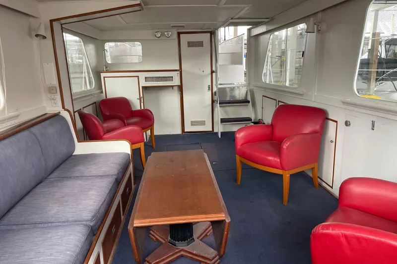 Slide: The Image of Interior of a 1958 Huckins Seafarer yacht with red chairs and a wooden table. - 18