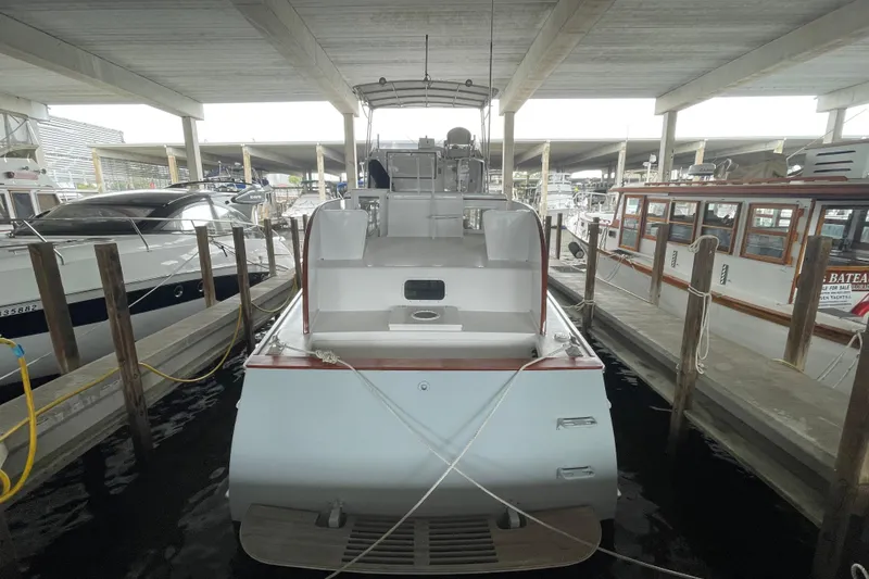 Slide: The Image of 1958 Huckins Seafarer yacht docked in a covered marina, showcasing classic design. - 2