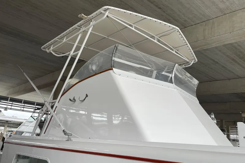 Slide: The Image of 1958 Huckins Seafarer boat with canopy, under a concrete structure. - 4