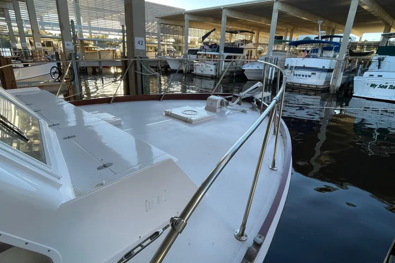 Slide: The Image of 1958 Huckins Seafarer boat docked in a marina, surrounded by other vessels. - 6