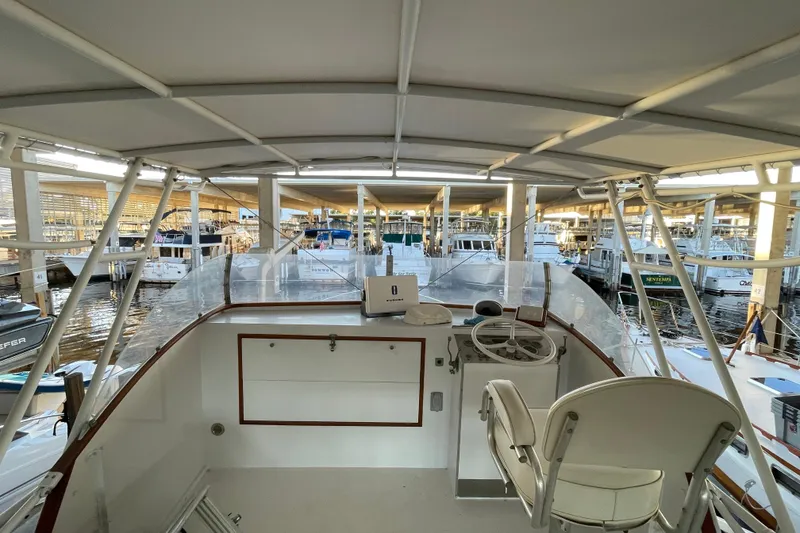 Slide: The Image of 1958 Huckins Seafarer boat interior at marina, featuring helm and seating area. - 9