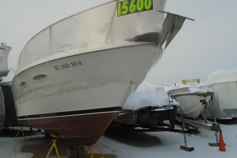 Slide: The Image of 1989 Sea Ray 300 Weekender boat in storage, covered in snow, with price tag displayed. - 1
