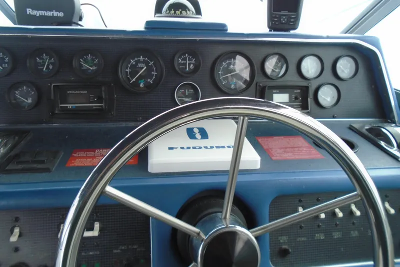 Slide: The Image of 1989 Sea Ray 300 Weekender dashboard with steering wheel and navigation instruments. - 13