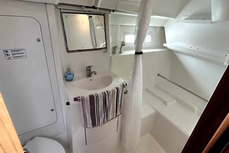 Slide: The Image of Bathroom interior of 2005 Beneteau Oceanis 373 yacht, featuring sink, mirror, and shower area. - 11