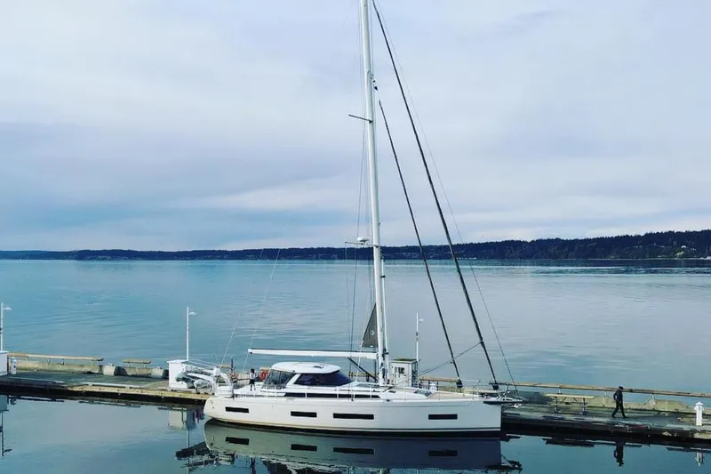 The Image of 2020 Amel 50 yacht docked at a serene marina with calm waters. - 0
