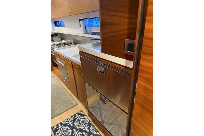 Slide: The Image of Modern kitchen interior of 2020 Amel 50 yacht with wood cabinetry and stainless steel appliances. - 24